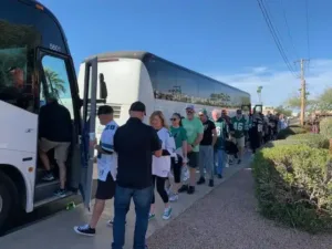 people lining up for a charter bus ride